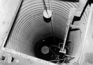 Picture of electronic level transmitter – a measuring tape – dropping into culvert that goes out to Red River, City of Winnipeg Photo