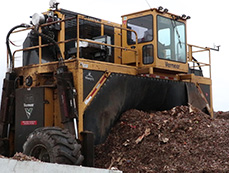 A large machine is used to turn the compost