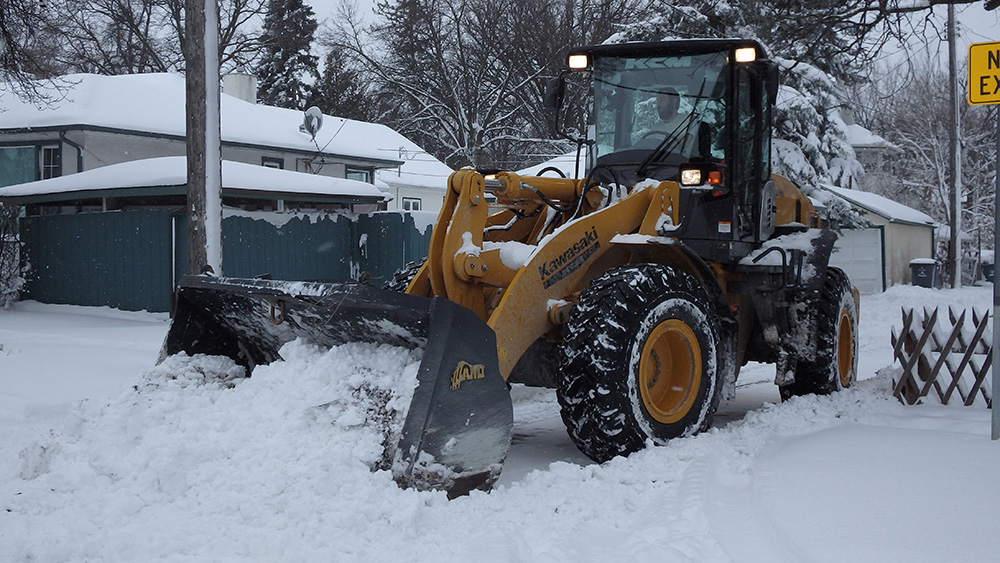 Front end loaders working to clear back lanes across Winnipeg