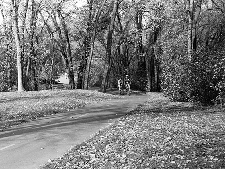 Cyclists biking along a path in Kildonan Park, 1976.