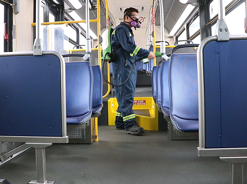 Transit employee spraying bus seat