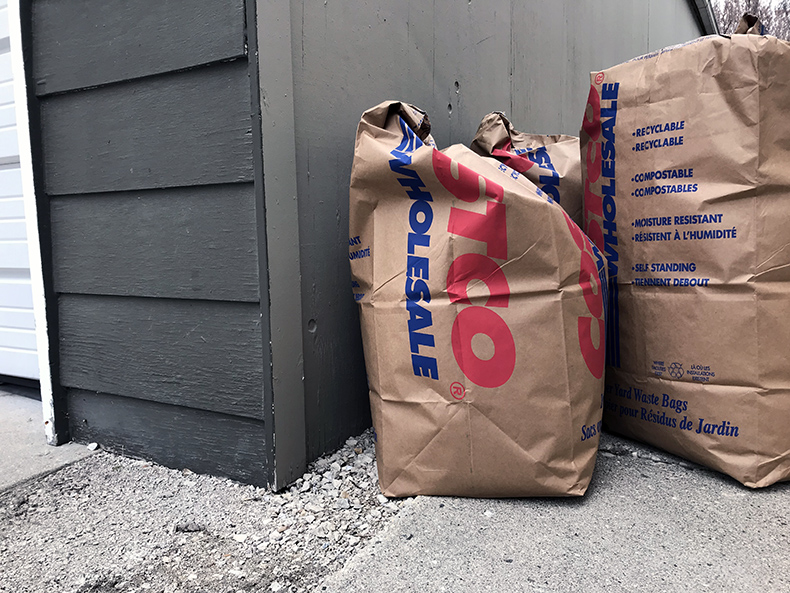 leaf compost bags leaning against garage