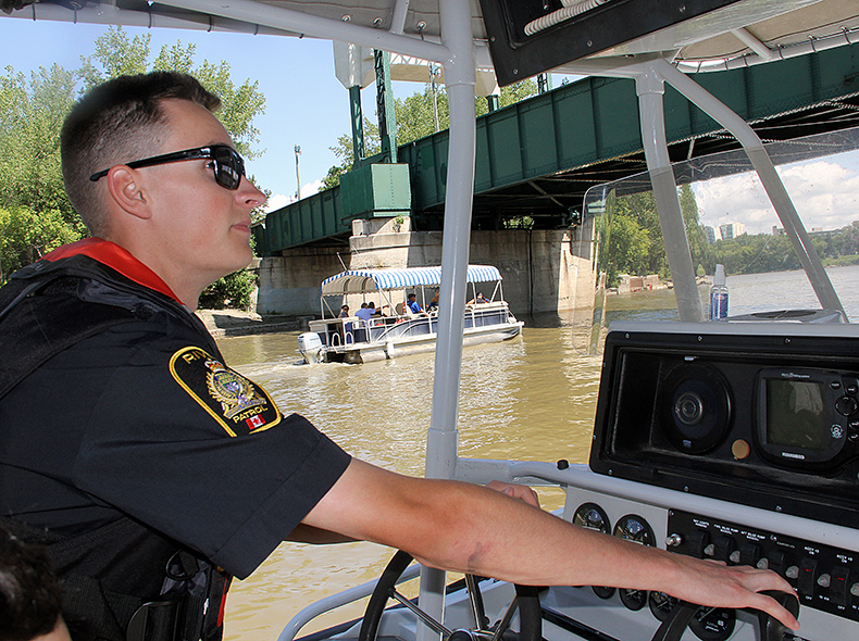 Police officer driving boat on a river