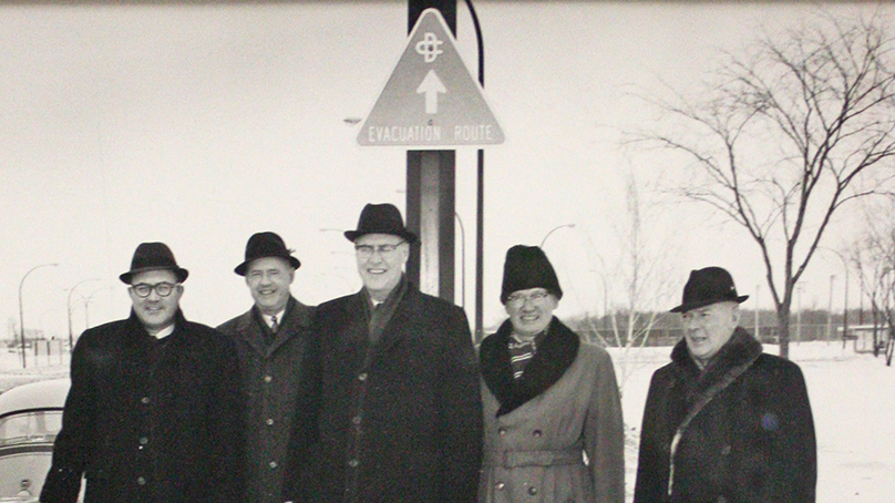 Installation of evacuation route signs in Metropolitan Winnipeg with A. Bentley, Provincial Coordinator of Emergency Measures Organization and Metro officials Bernie Wolfe, R.H.G. Bonnycastle, Andrew Currie, and James S. Mulholland, February 1966. City of Winnipeg Archives, Art Collection, Item AW00096.