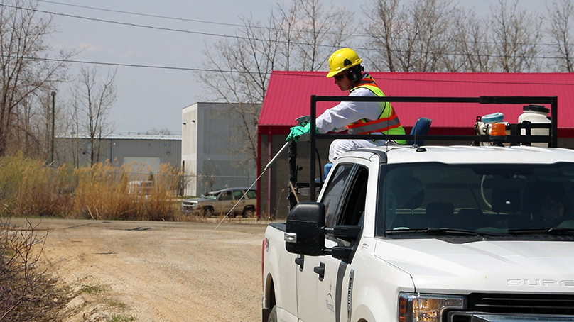 Employee spraying larvicide from a truck.