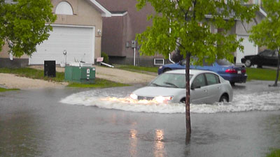Car driving through high water level from heavy rain